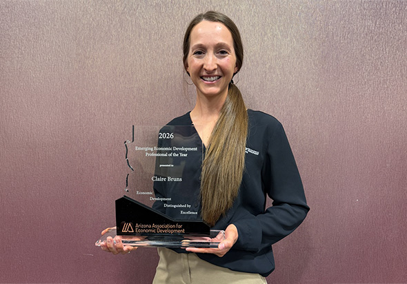 City of Goodyear’s Claire Bruns honored as 2026 Emerging Economic Developer of the Year. Claire is standing in front of a pinkish background holding her award.